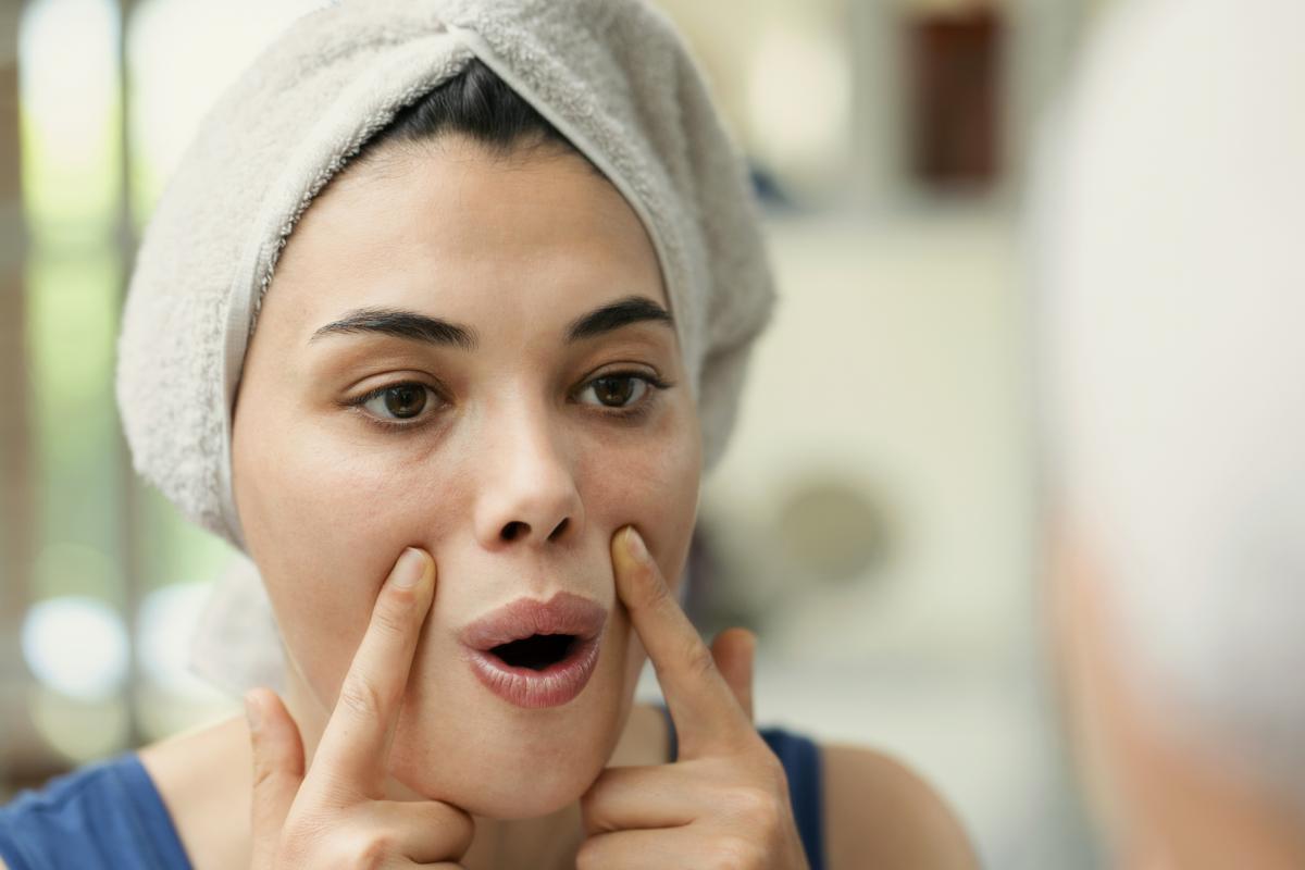 Una mujer haciendo yoga facial.