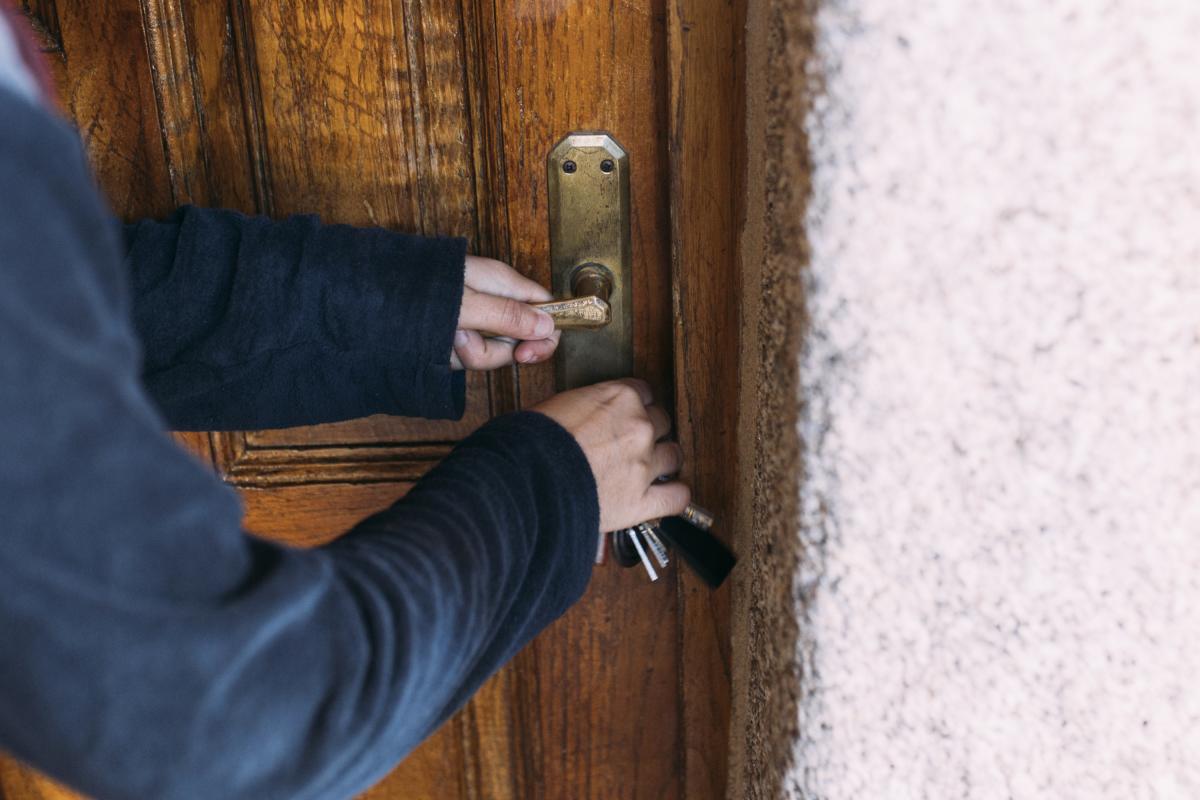 Un hombre echando la llave de casa.
