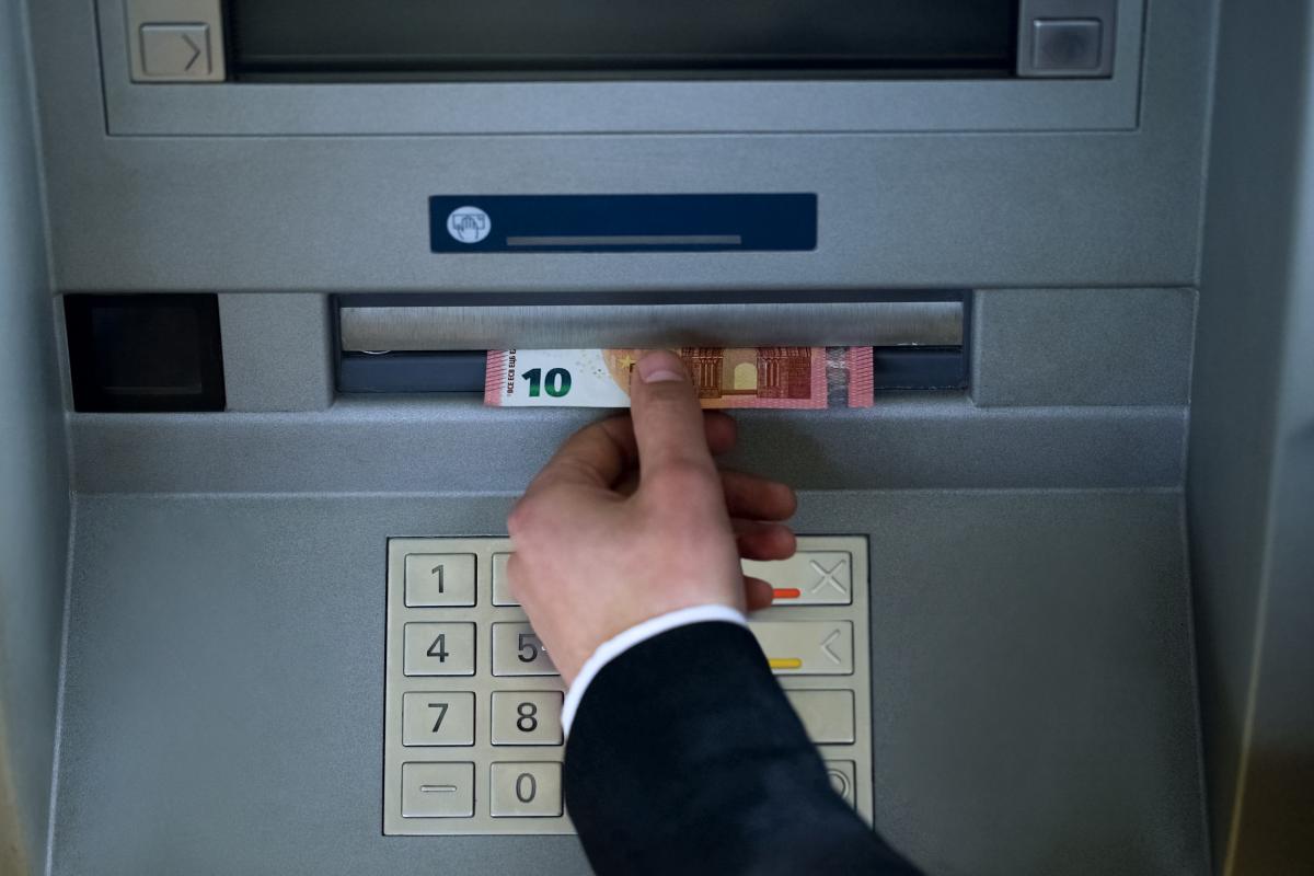 Imagen de archivo de una persona retirando dinero en metálico de un cajero automático.