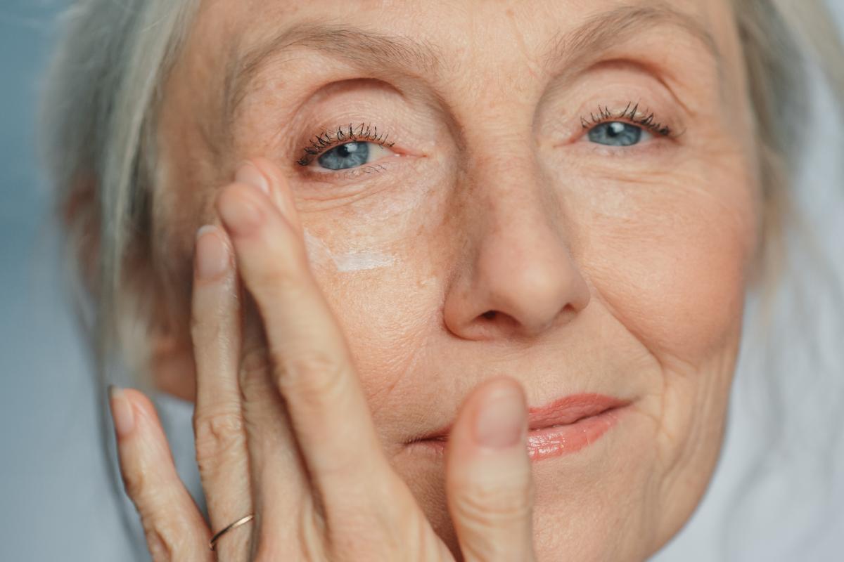 Una mujer aplicándose una crema.