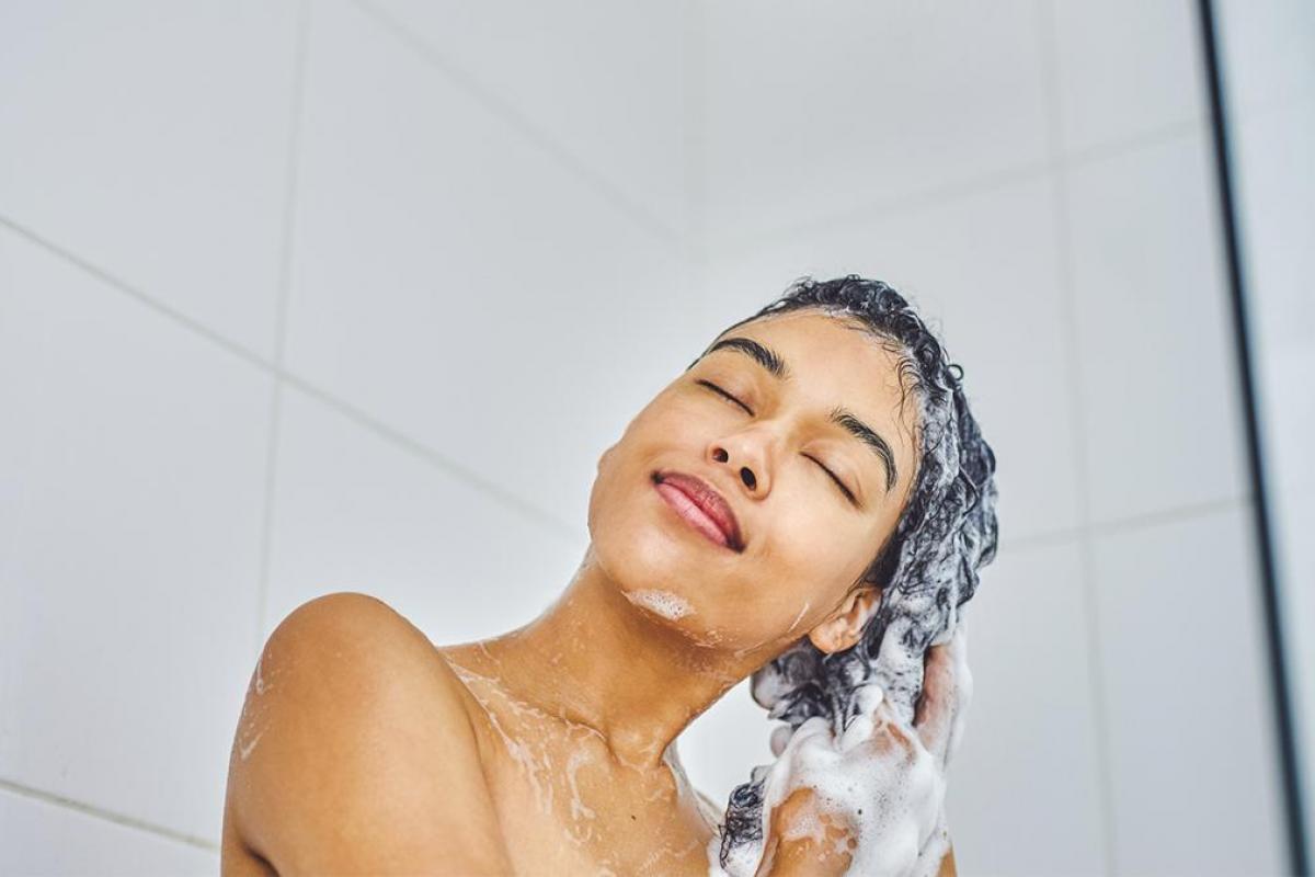 Una mujer aplicándose champú