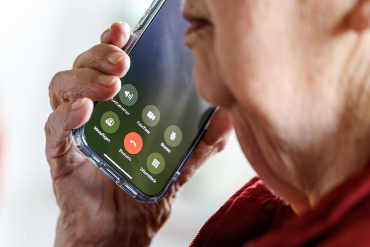 Una mujer de 90 años responde una llamada en su teléfono móvil.