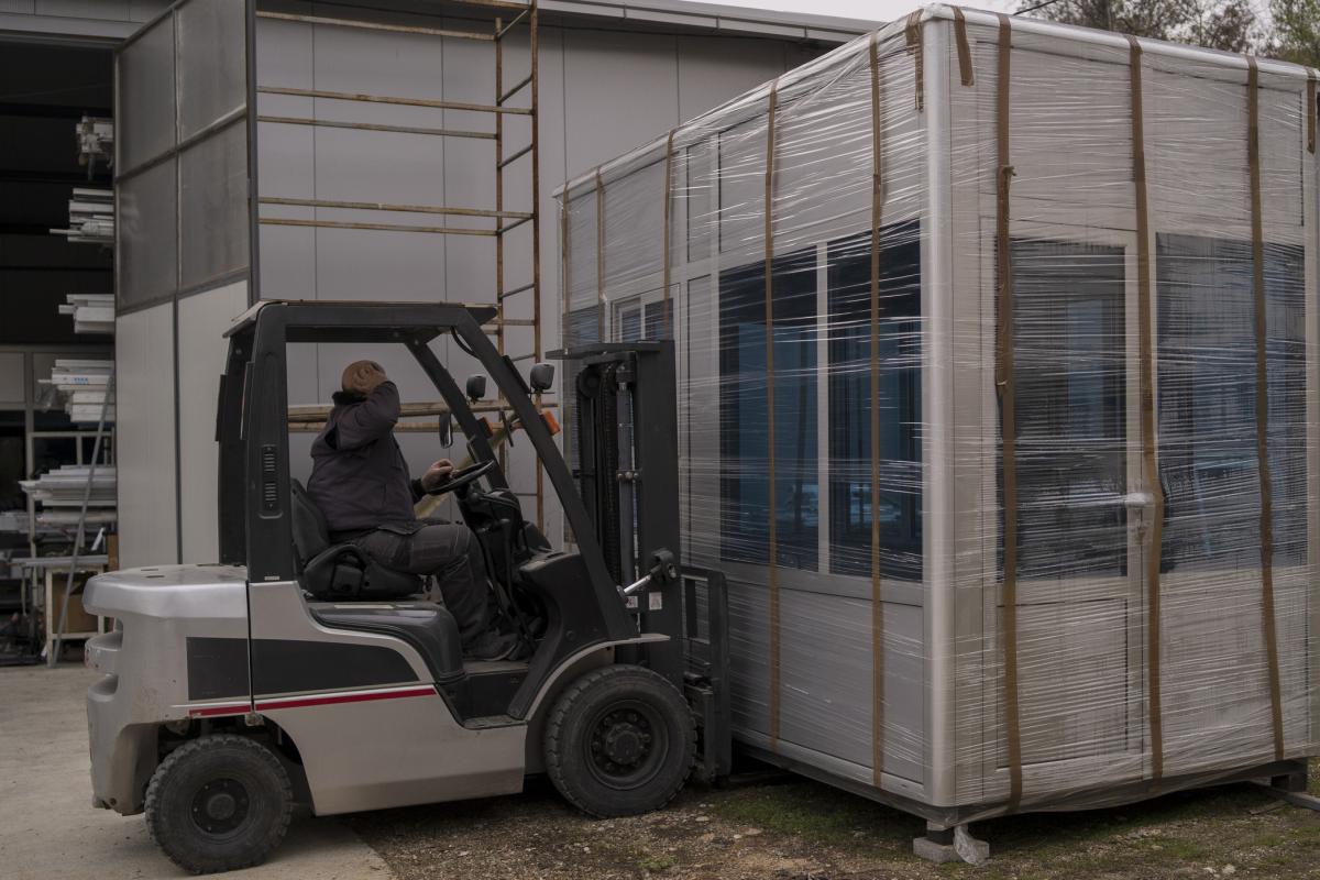 Imagen de archivo de un operario transportando un módulo de una vivienda prefabricada.