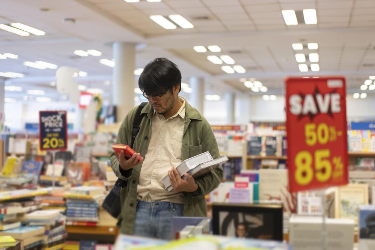 Un hombre ojea libros en una librería.