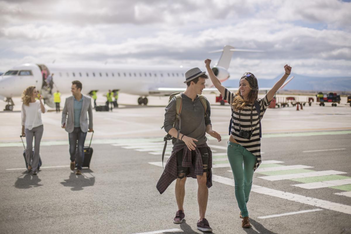 Imagen de turistas llegando a su destino en un aeropuerto.