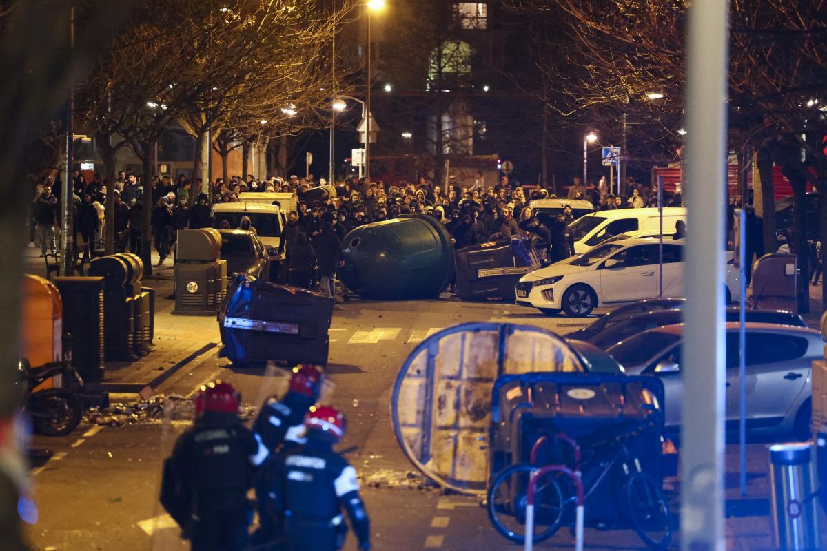 Varios manifestantes vuelcan contenedores durante los disturbios que se producen tras el operativo para el desalojo del gaztexe, este jueves en el barrio bilbaíno de Rekalde.