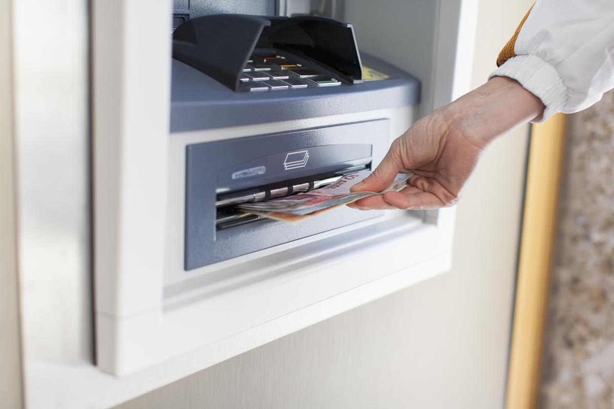 Una persona sacando dinero en un cajero automático, en una imagen de archivo.