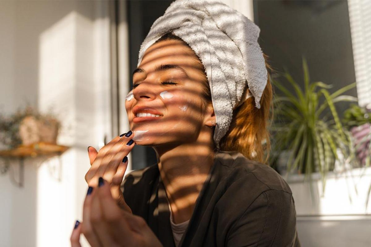 Una chica aplicándose crema.