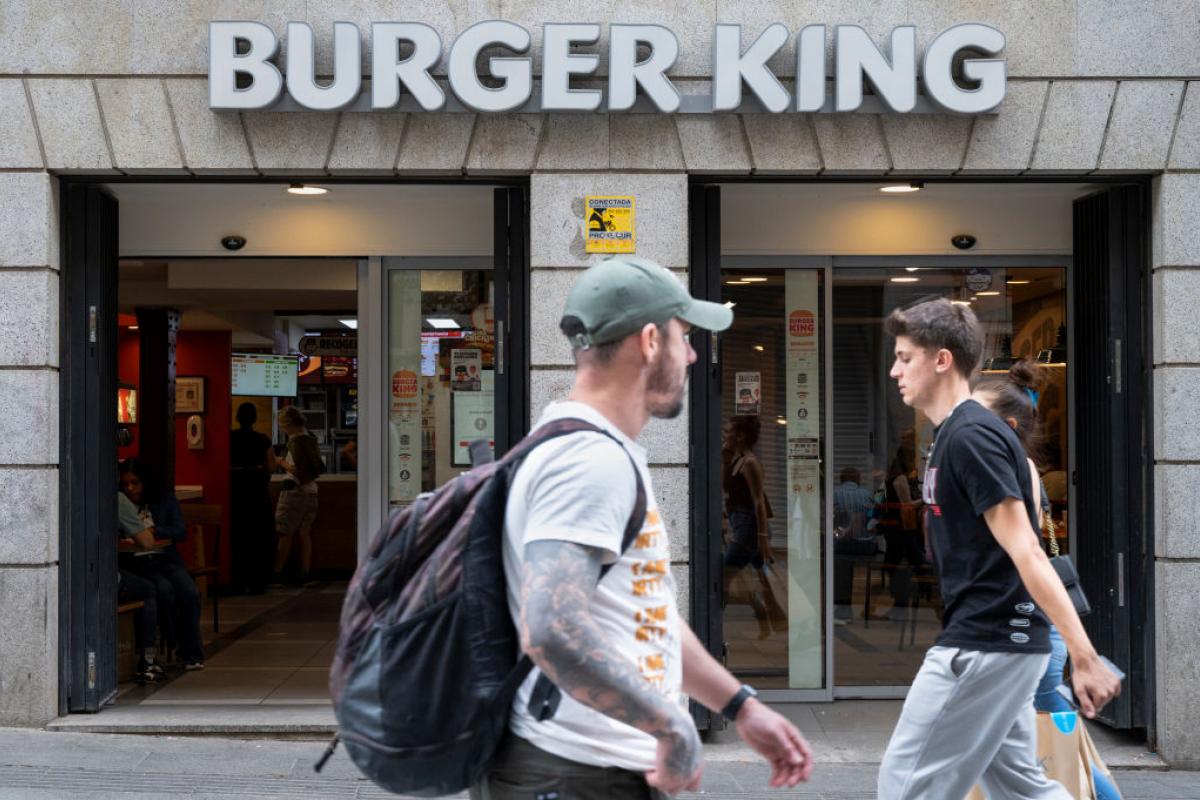 La gente pasa junto a un restaurante de Burger King en España.