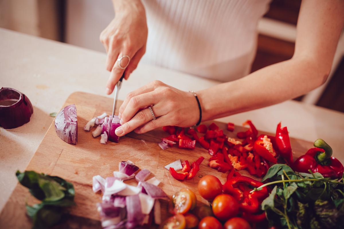 Mujer cocinando un plato con verduras