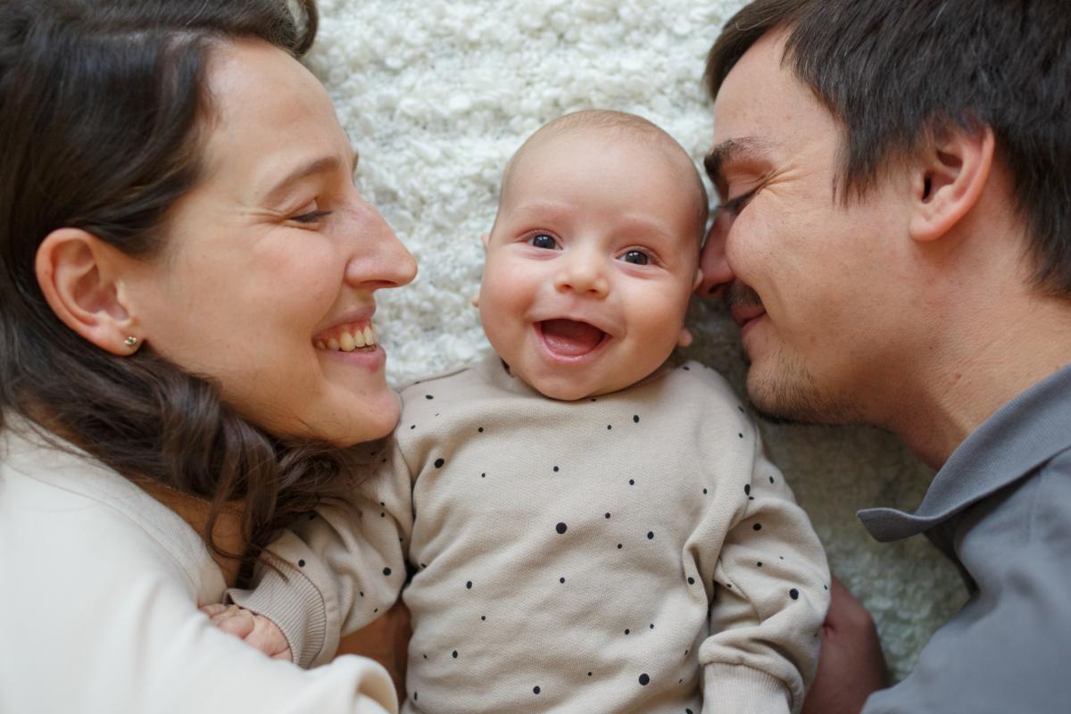 Madre, bebé y padre sonrientes.