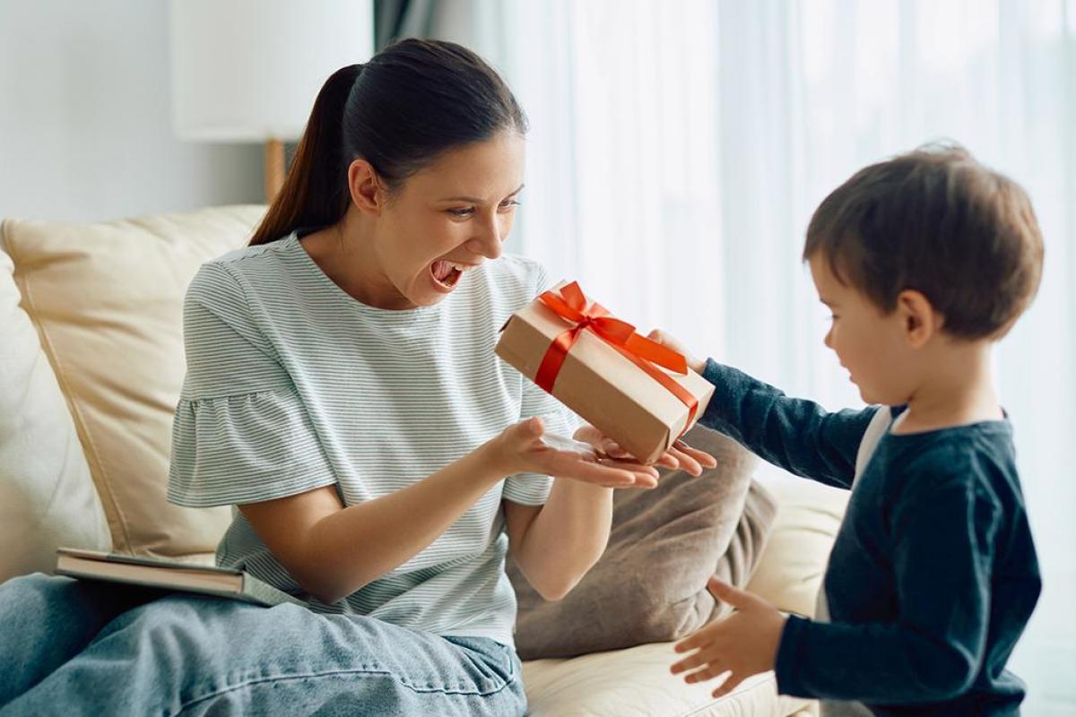 Un niño dándole un regalo a su madre