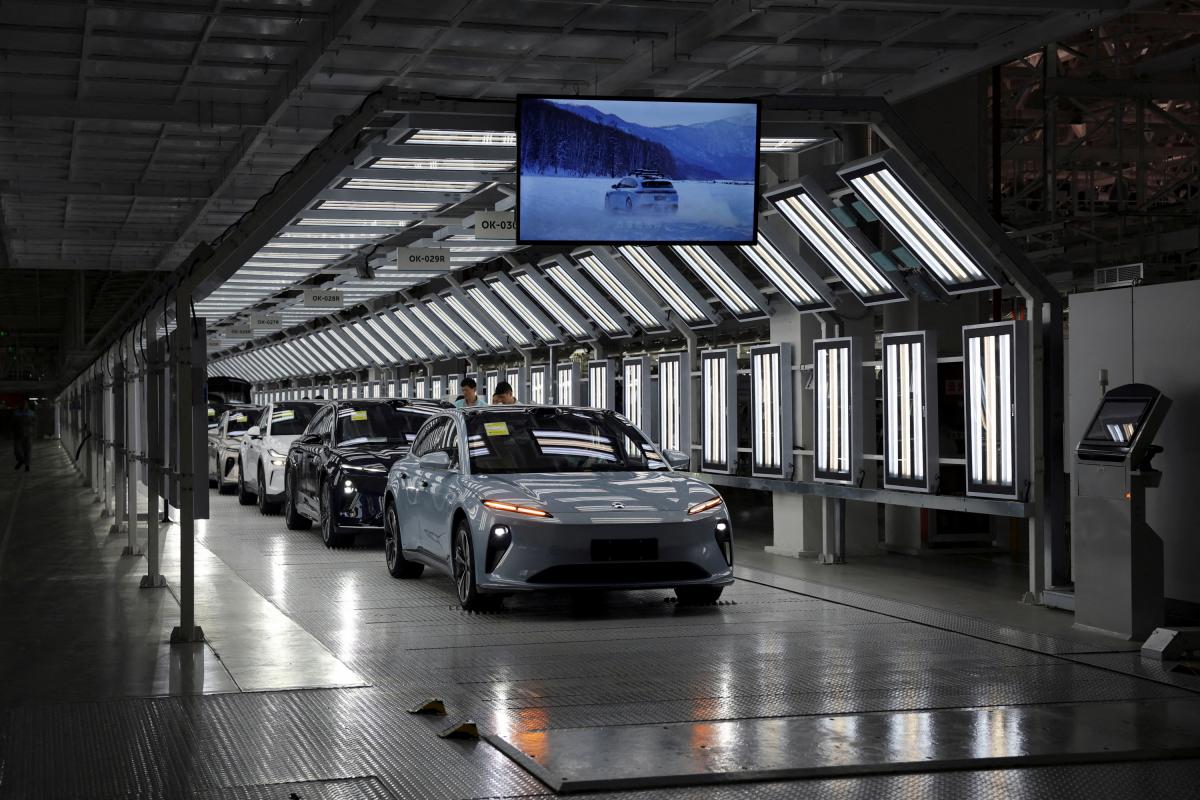 Los empleados trabajan en la línea de una fábrica de vehículos eléctricos en China.