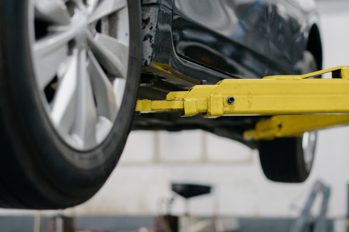 Imagen de un coche elevado en un taller.