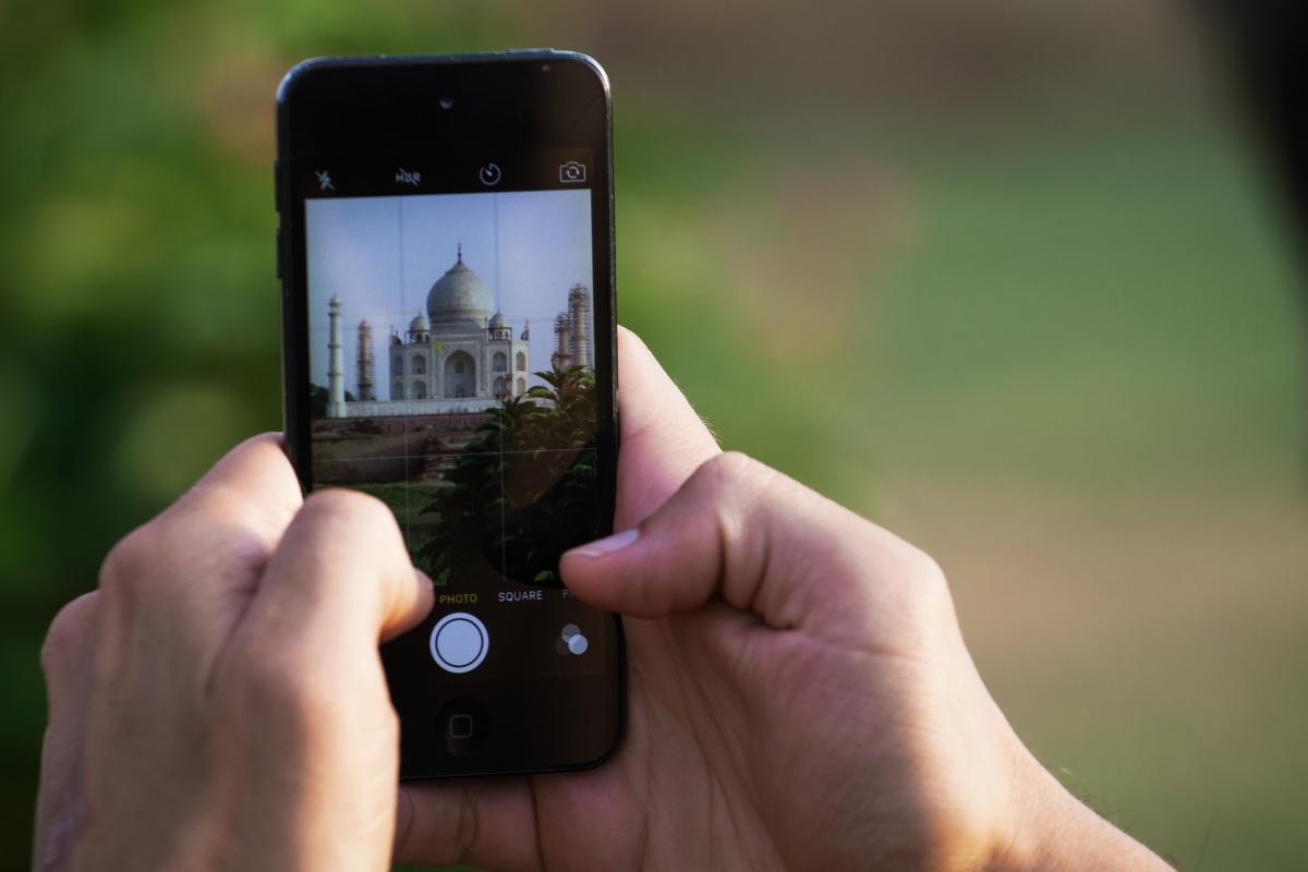 Imagen de archivo de una persona sacando una foto al Taj Mahal (India) con un móvil iPhone.