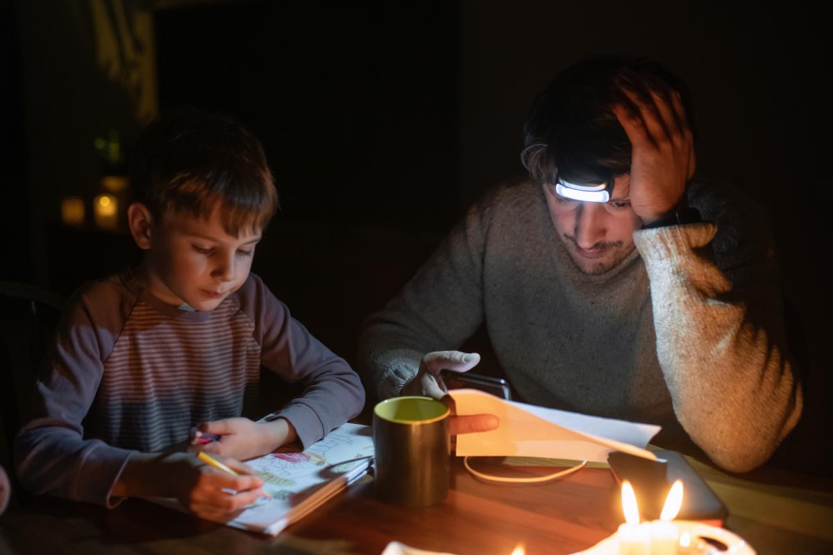 Familia sentada a la luz de las velas durante un apagón