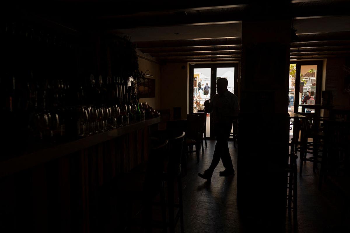 Un bar a oscuras, reflejo de millones de hogares y locales en España este lunes 28 de abril