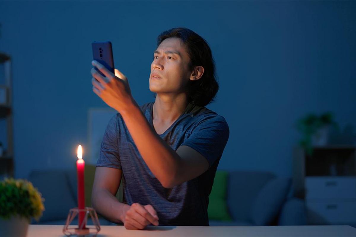Un hombre con una vela buscando cobertura en el móvil