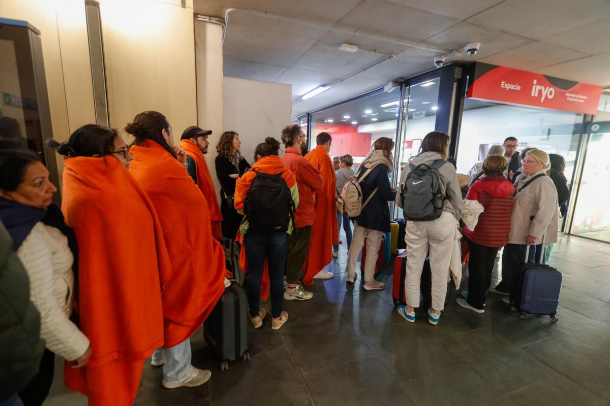 Un grupo de personas espera a la salida de los trenes en la estación de Delícias de Zaragoza para volver a sus casas este martes tras el apagón.