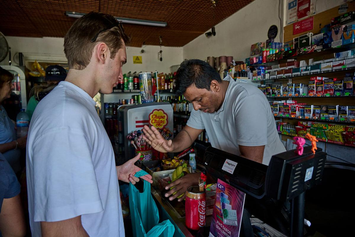 El responsable de una tienda en Portugal cuenta el dinero en efectivo durante el apagón que este lunes dejó la Península Ibérica a oscuras.