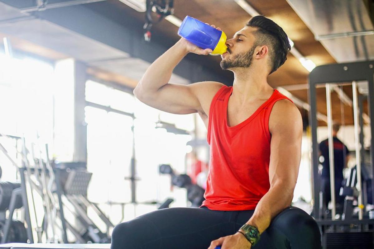 Un chico en el gimnasio bebiendo agua
