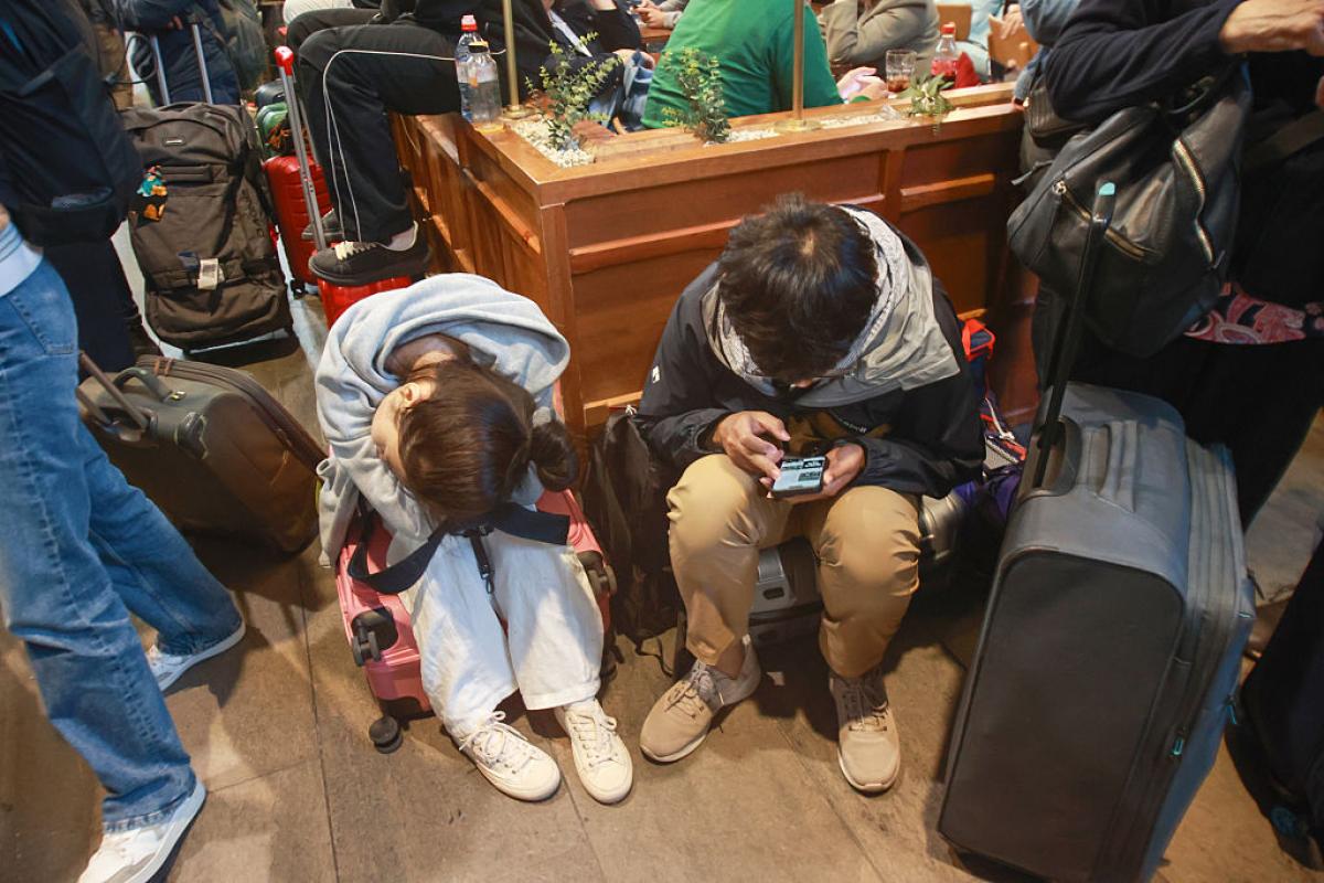 Caos y pasajeros esperando como pueden en la estación de Santa Justa en Sevilla este lunes