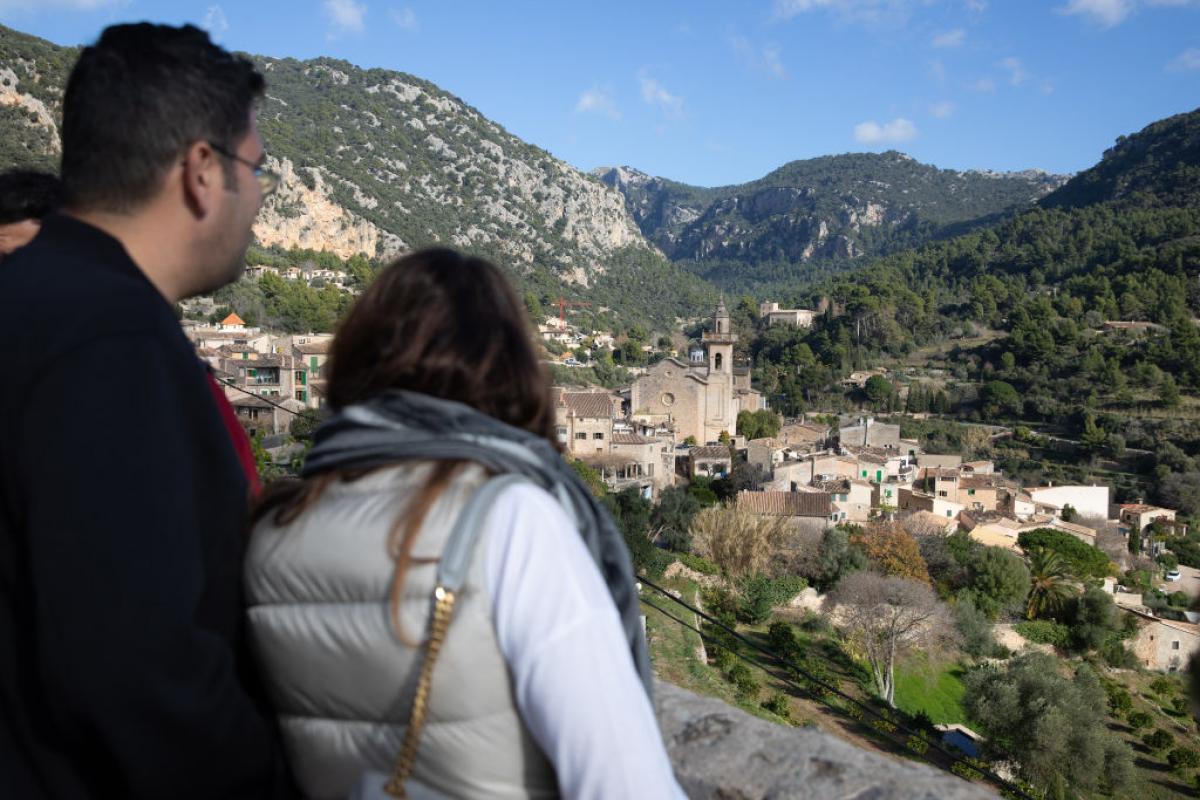 Una pareja de turistas observa desde la distancia el pueblo de Valldemossa, en Mallorca.