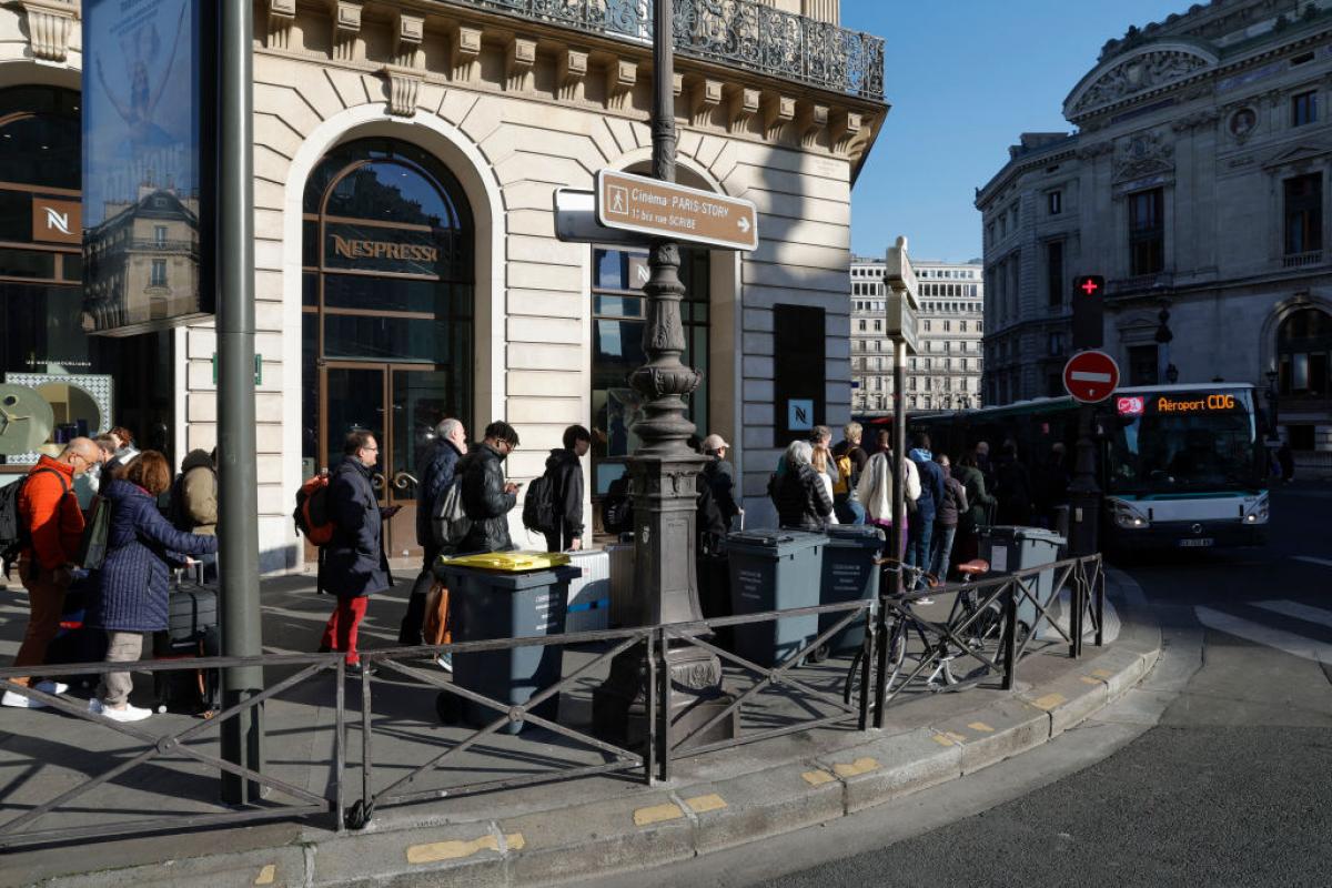 Pasajeros hacen cola para subirse a un autobús en el centro de París