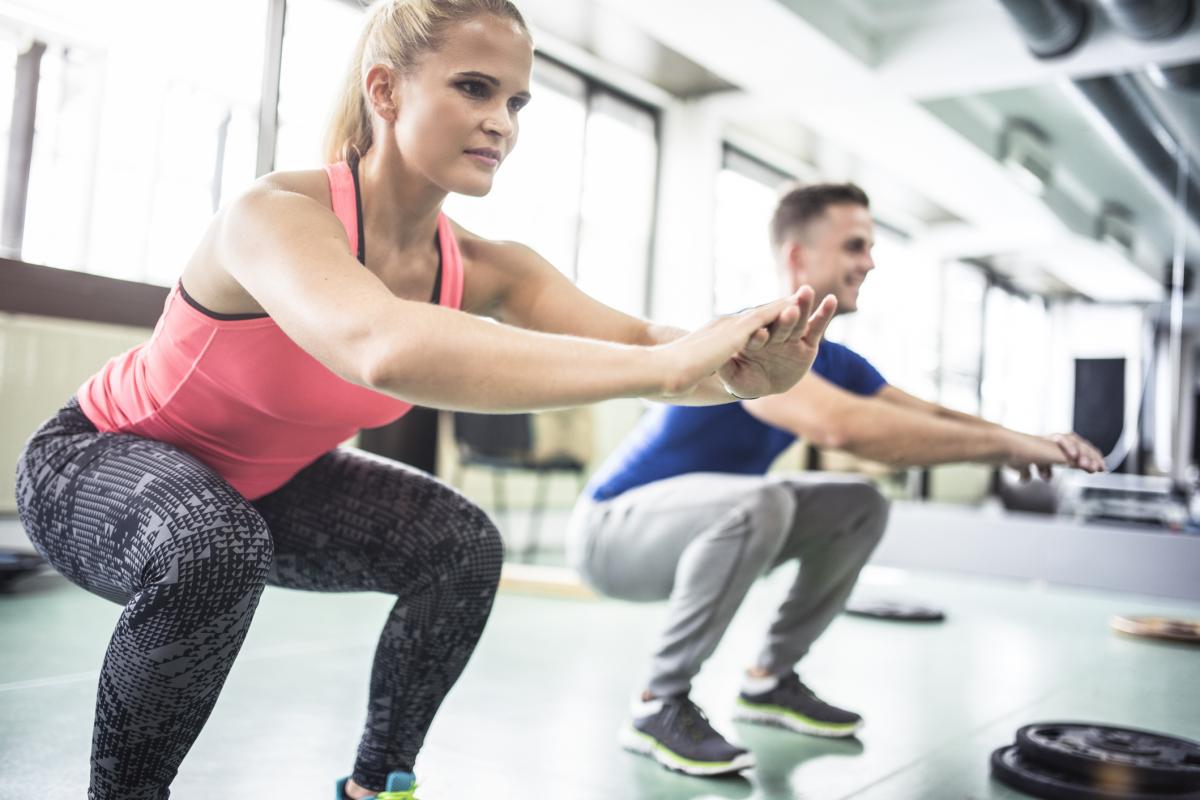 Dos personas haciendo sentadillas.