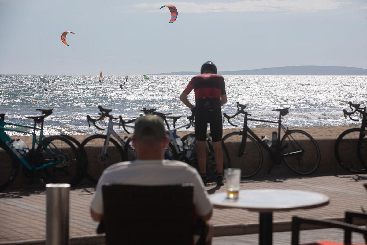 Un turista se toma una cerveza frente a la playa en Mallorca