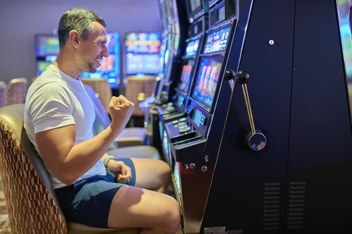 Un hombre celebra haber ganado un premio en un tragaperras.