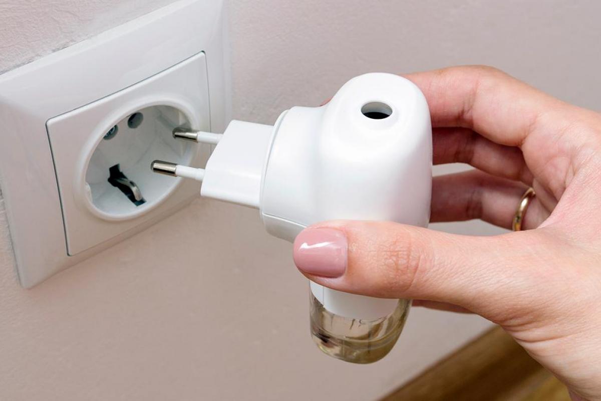 Una mano enchufando un antimosquitos.