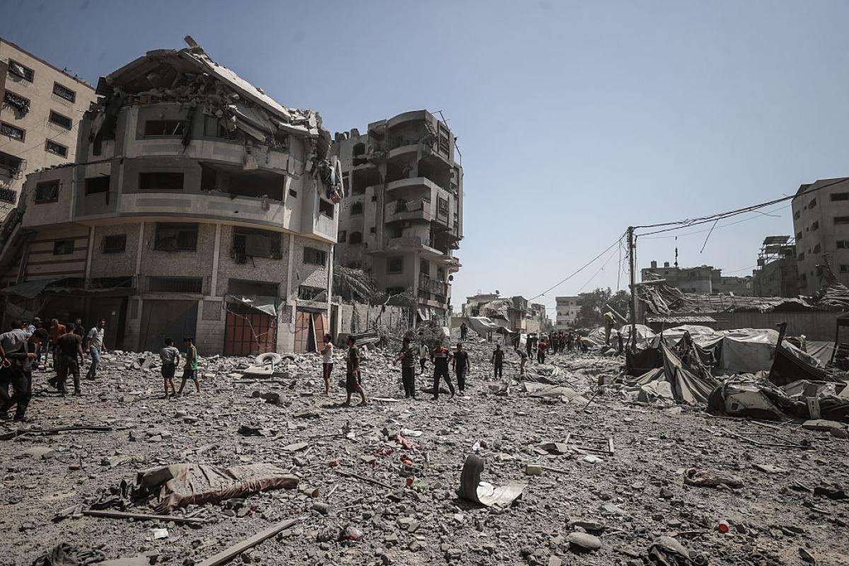 Grupos de palestinos caminan entre los escombros de lo que fue Gaza Central.