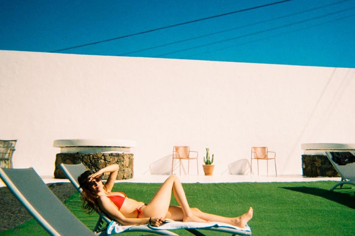 Una chica en una tumbona tomando el sol.