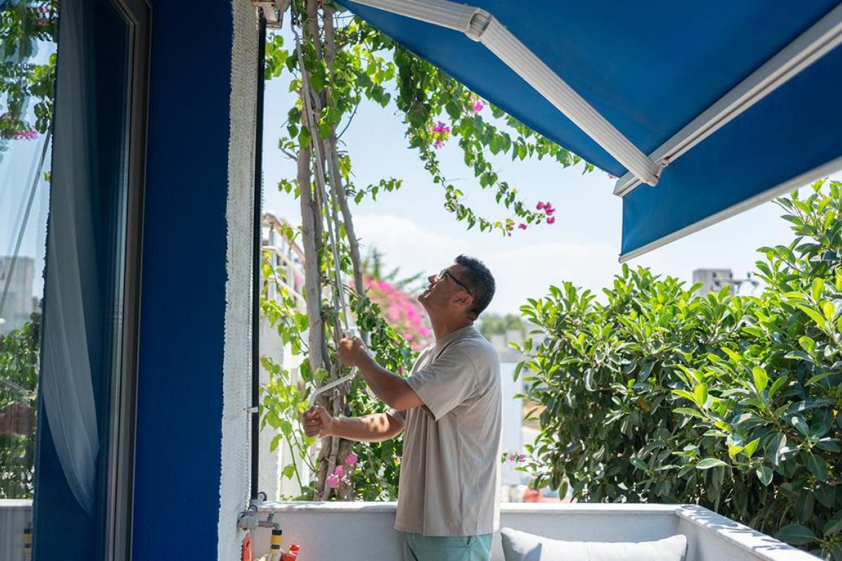 un hombre bajando un toldo preinstalado.