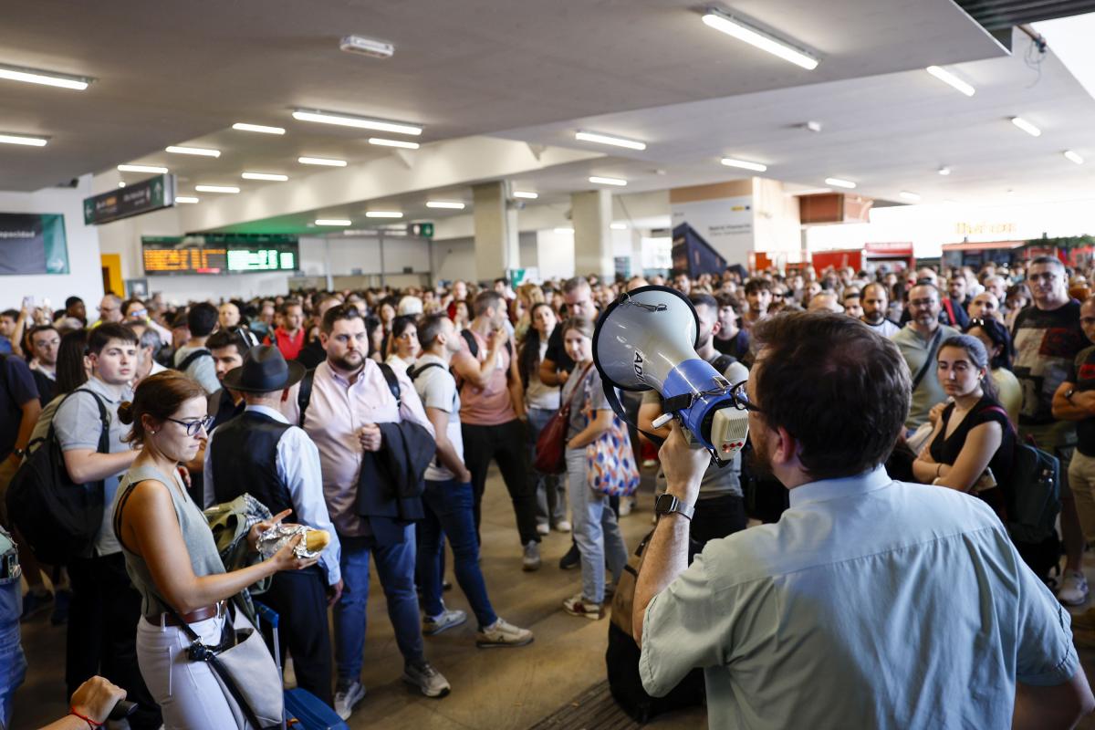 Un empleado informa a los pasajeros sobre los retrasos en la estación de Madrid-Chamartín.