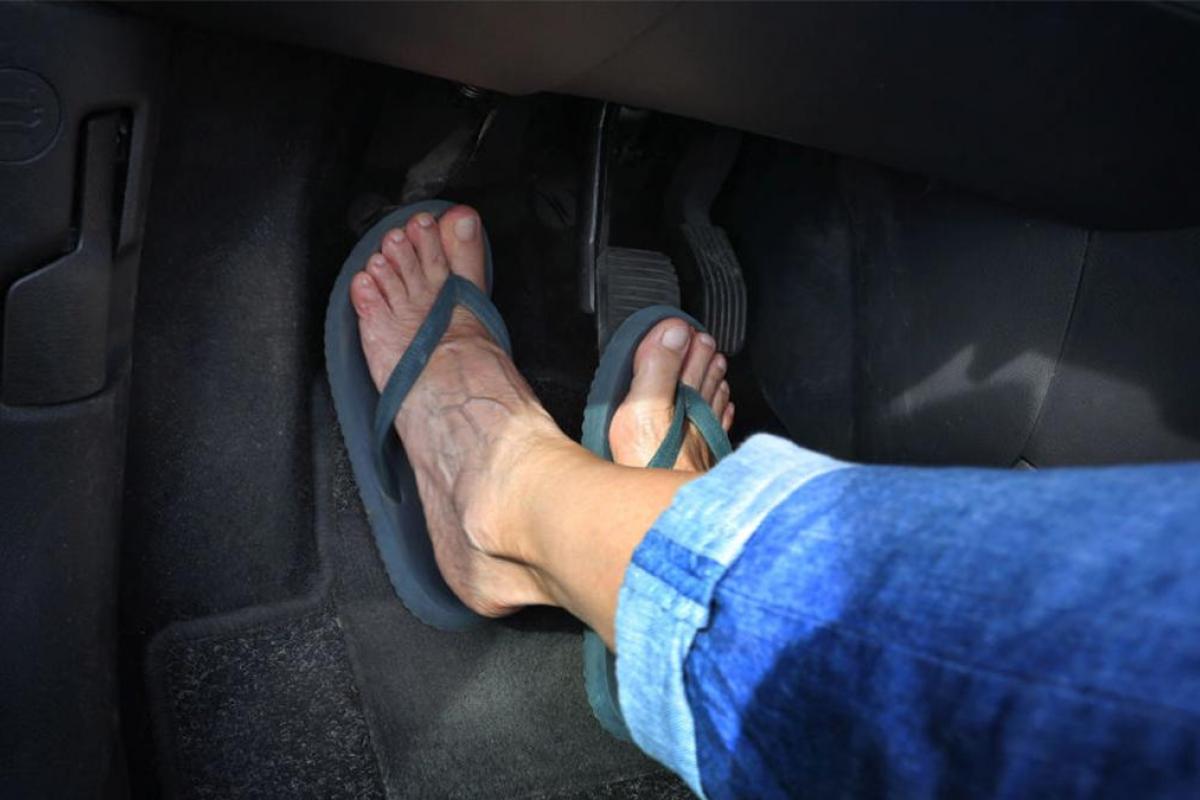 Una persona conduciendo con chanclas.