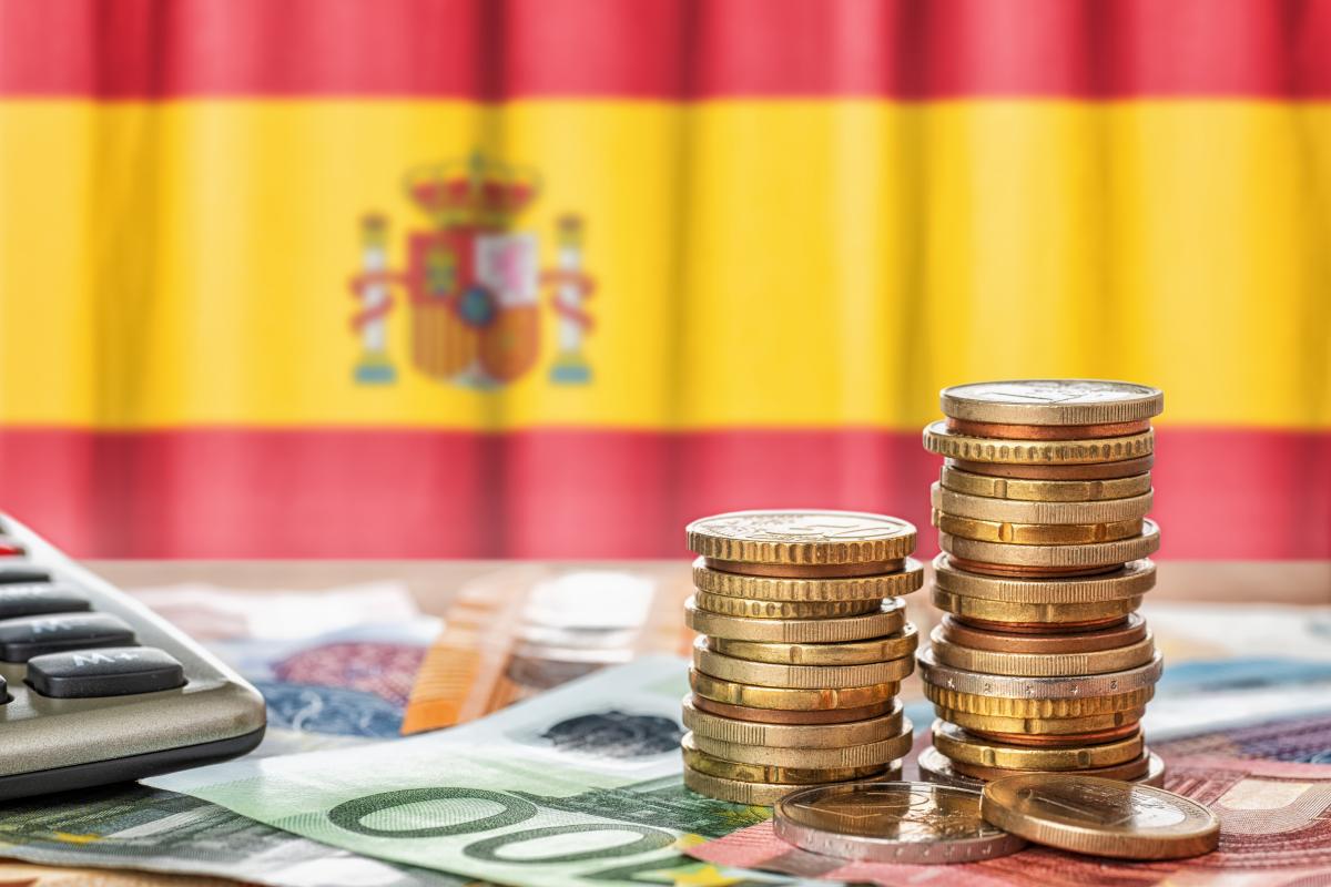 Euros con la bandera de España de fondo.