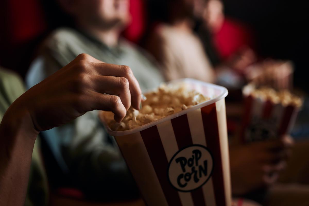 Una persona comiendo palomitas en el cine.