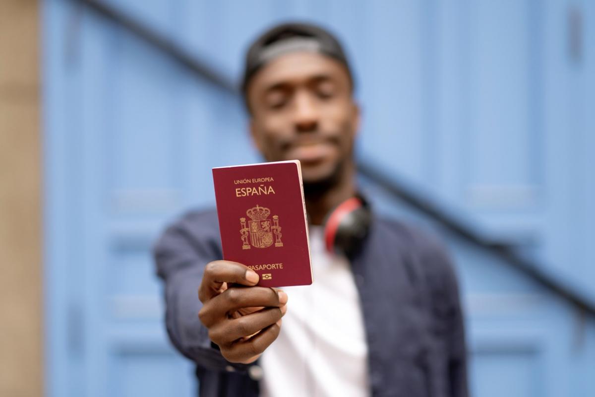 Un hombre sostiene el pasaporte español