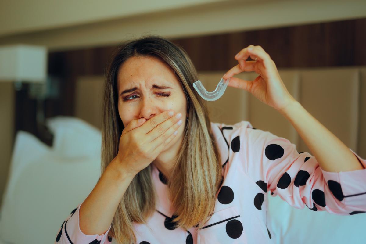 Una chica se coloca la cédula de descarga para el bruxismo.