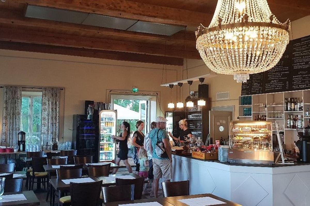 Interior del restaurante Annan Kartano, en Helsinki, con su lámpara de araña y barra de autoservicio.