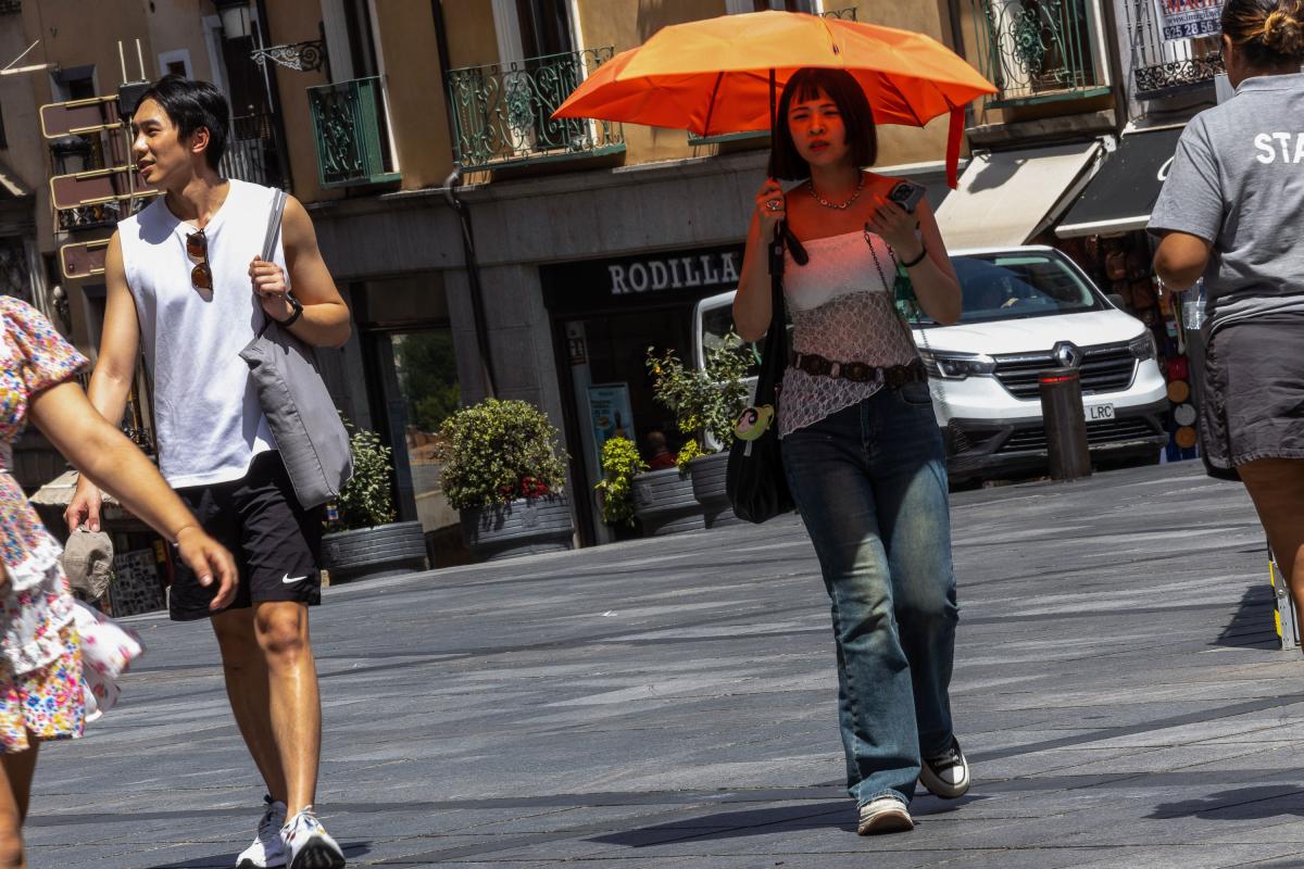Varias personas se protegen del sol en el centro de Toledo, este jueves.