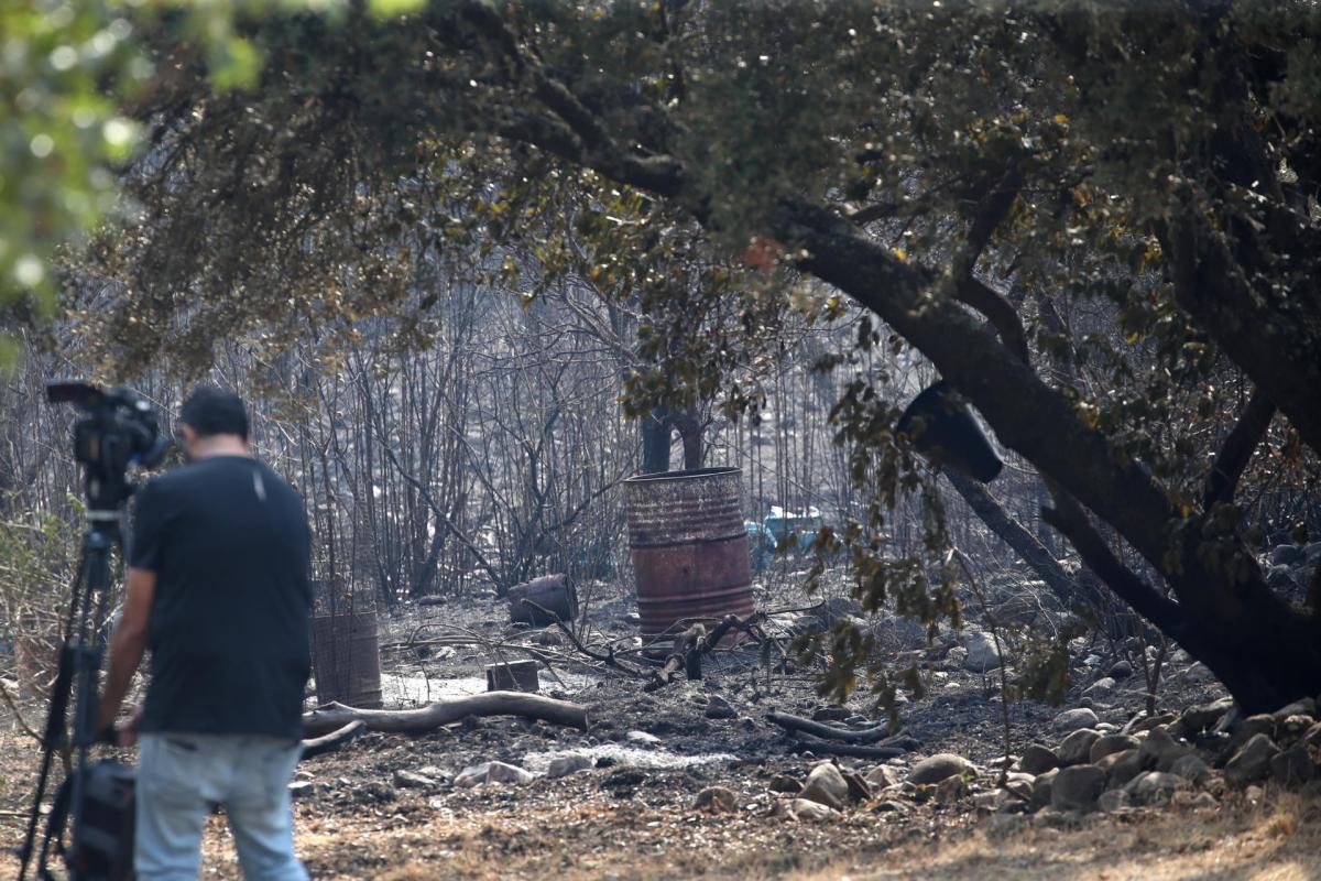 Un reportero toma imágenes tras el paso del incendio en Carucedo (León) este lunes 11 de agosto de 2025.