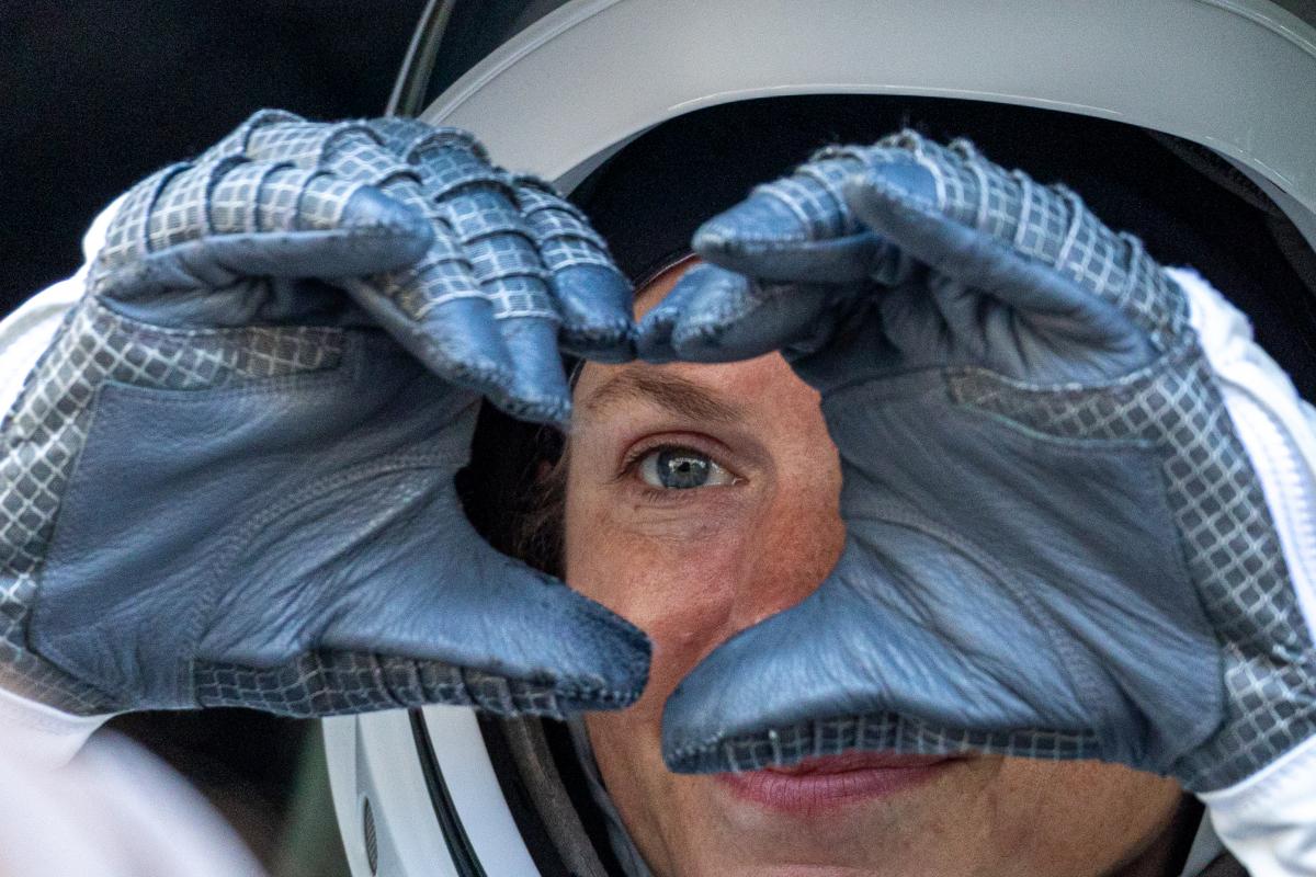 Una astronauta dibuja un corazón con las manos antes de partir hacia la Estación Espacial Internacional (EEI), desde el Kennedy Space Center, en Florida (EEUU).