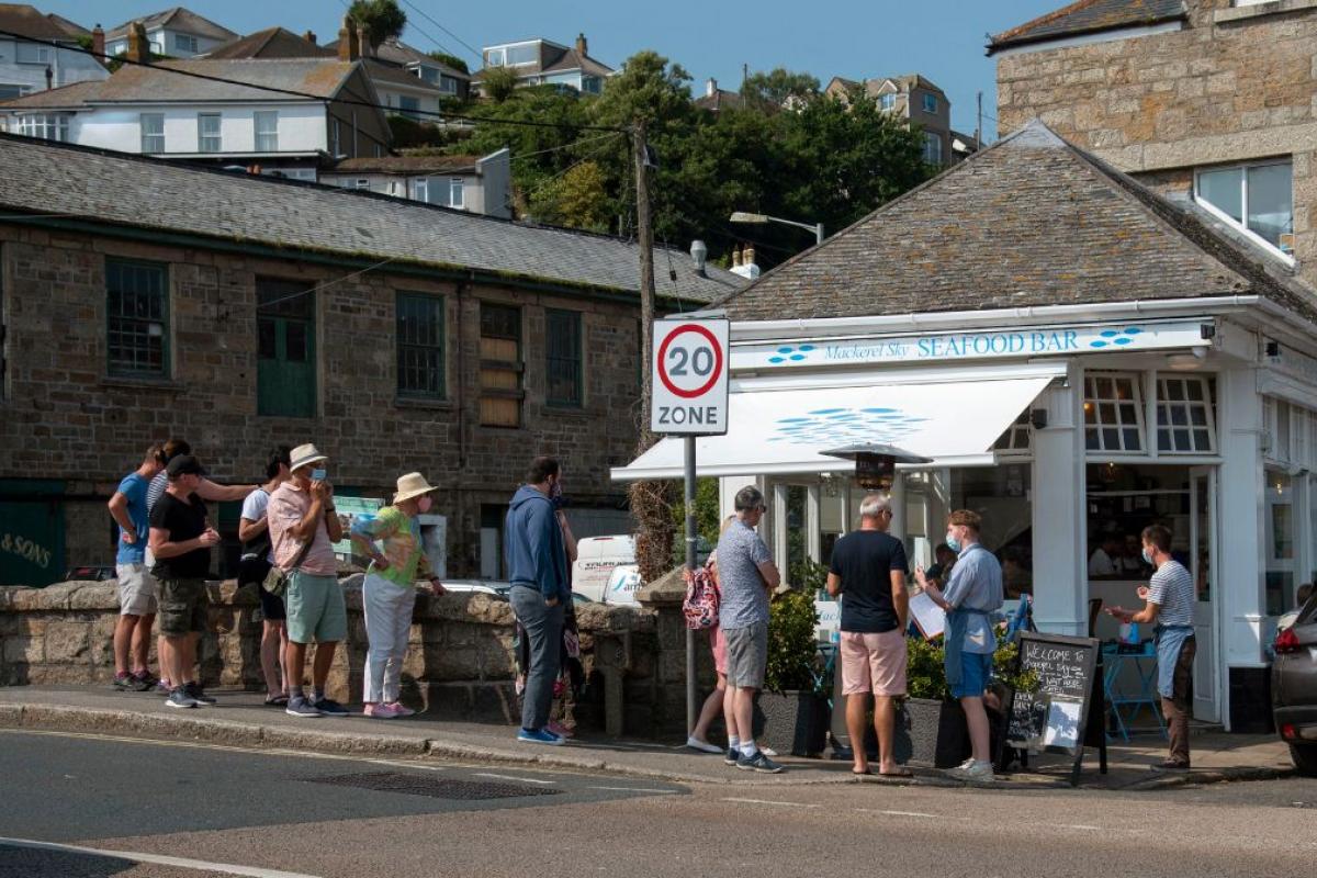 Personas haciendo cola para entrar a un restaurante