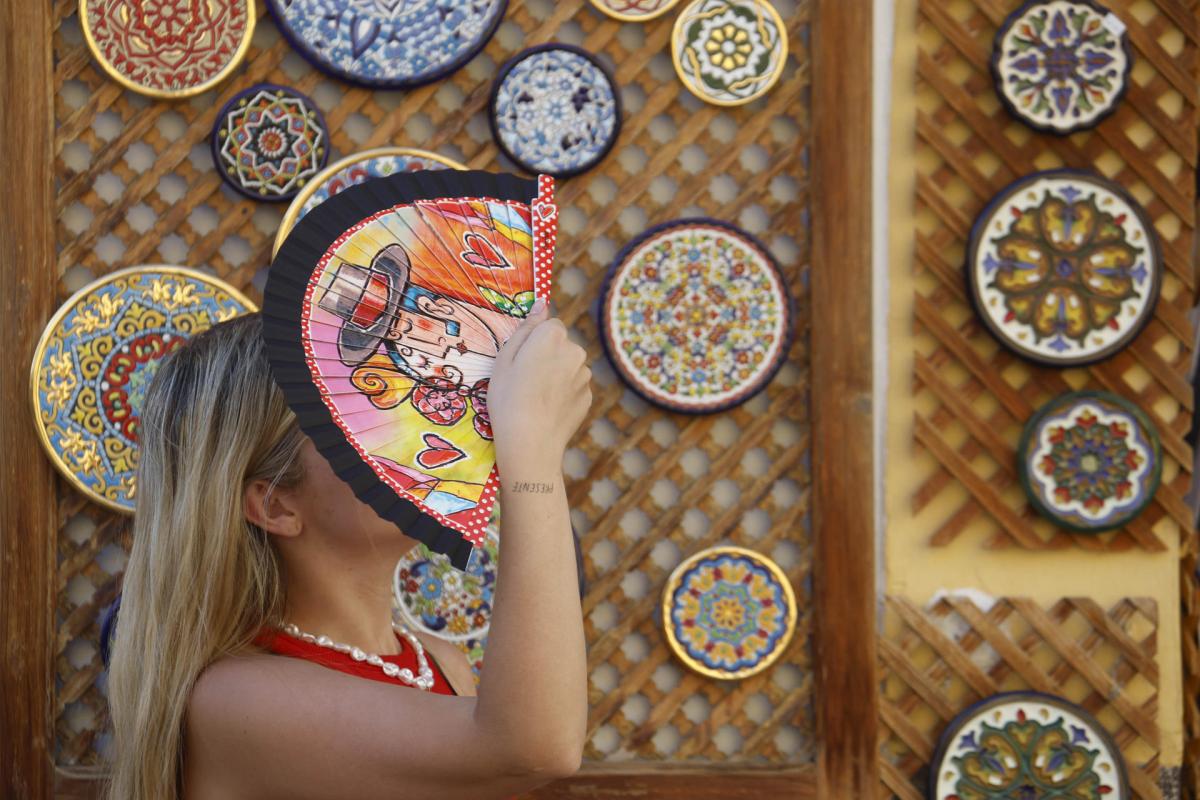 Una turista se cubre la cabeza con un abanico mientras camina por los alrededores de la Mezquita-Catedral de Córdoba el 12 de agosto de 2025.