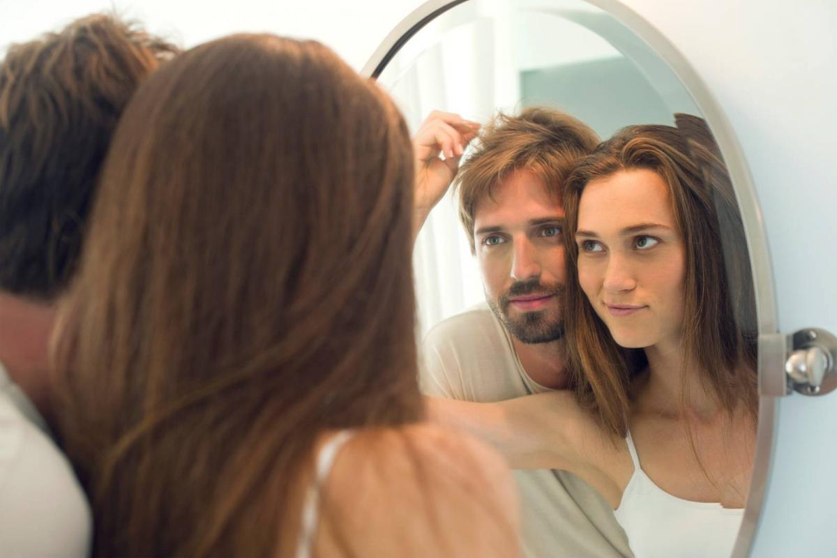 Una pareja se mira en el espejo