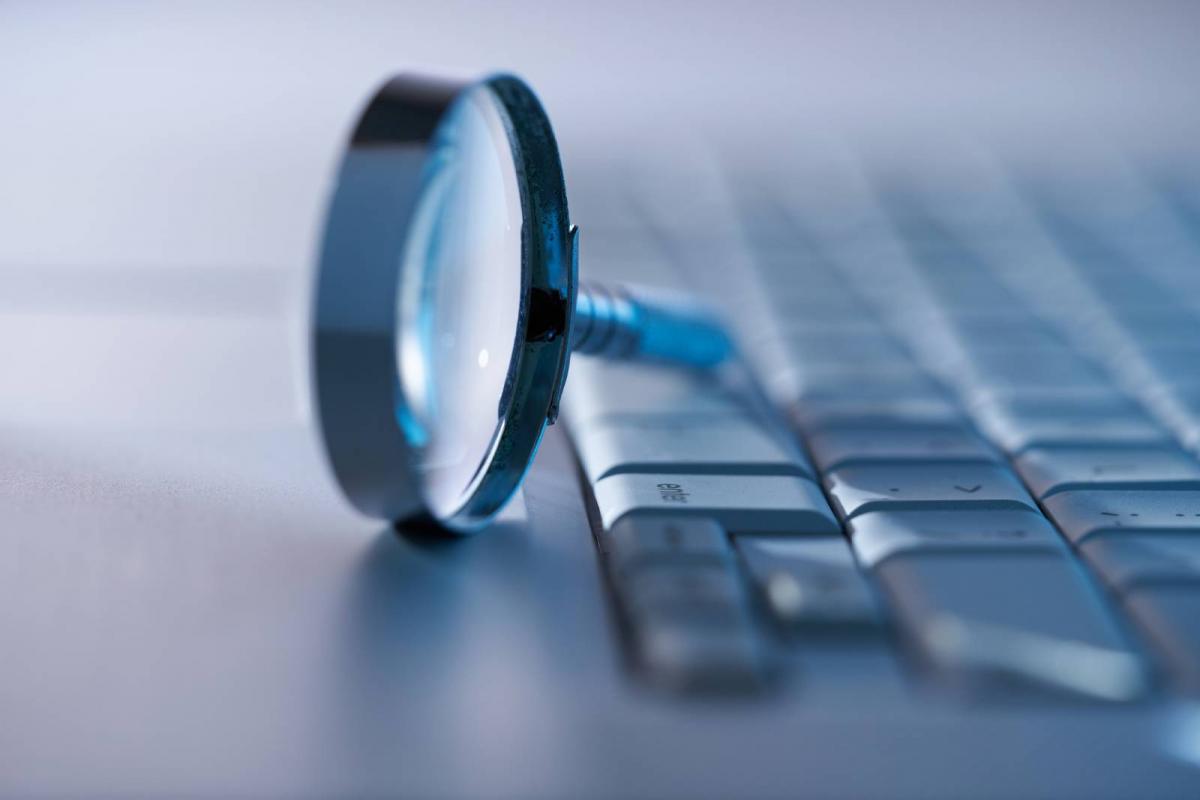 Lupa al lado de un teclado