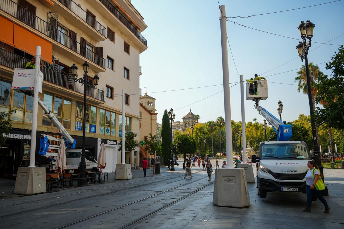 Trabajadores instalando los nuevos toldos en Sevilla.